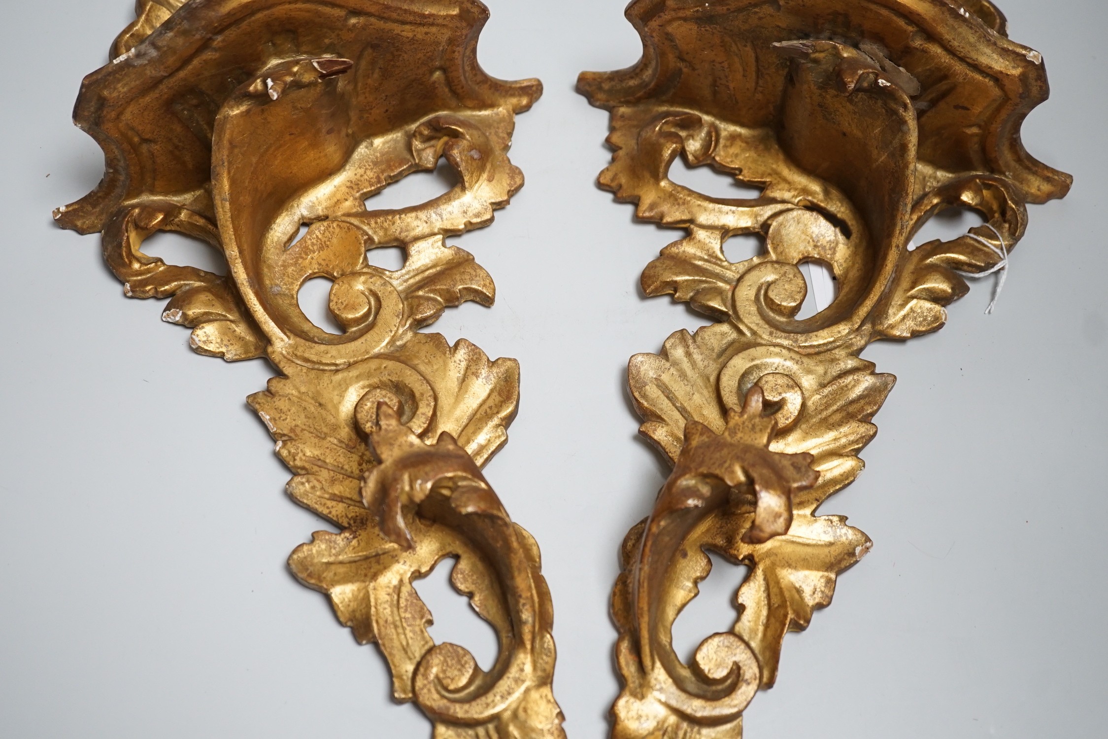 A pair of Italian gilt wood wall brackets in rococo style, early 20th century, 44cm long